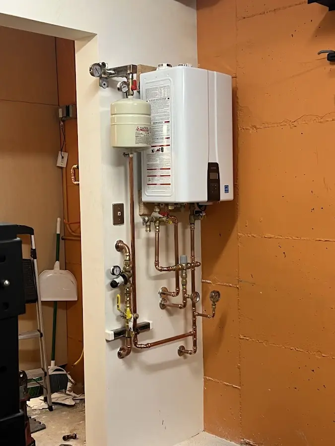 Plumbing technician inspecting water heater connections in Hunters Creek